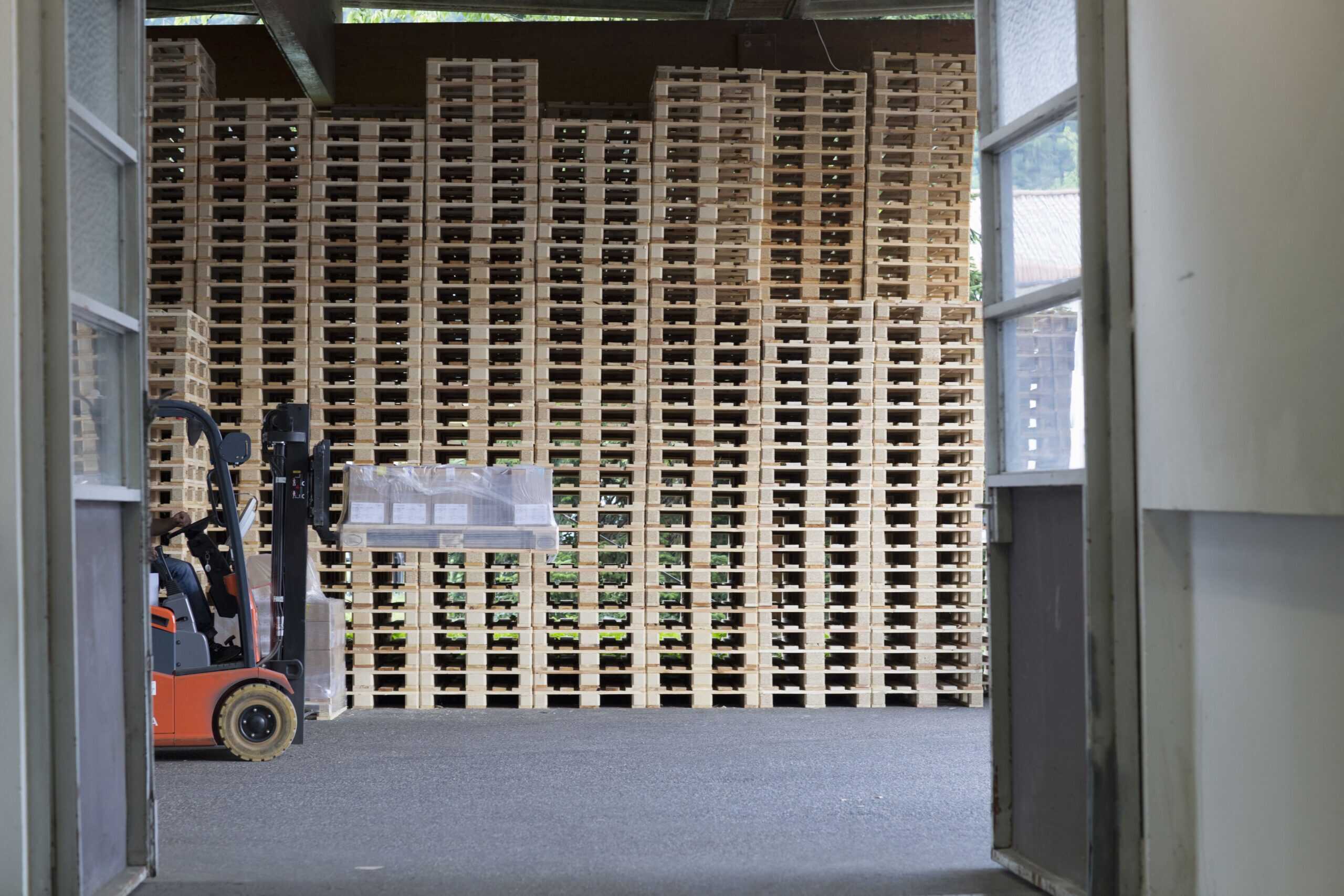 Forklift loading pallets inside truck trailer with bracing